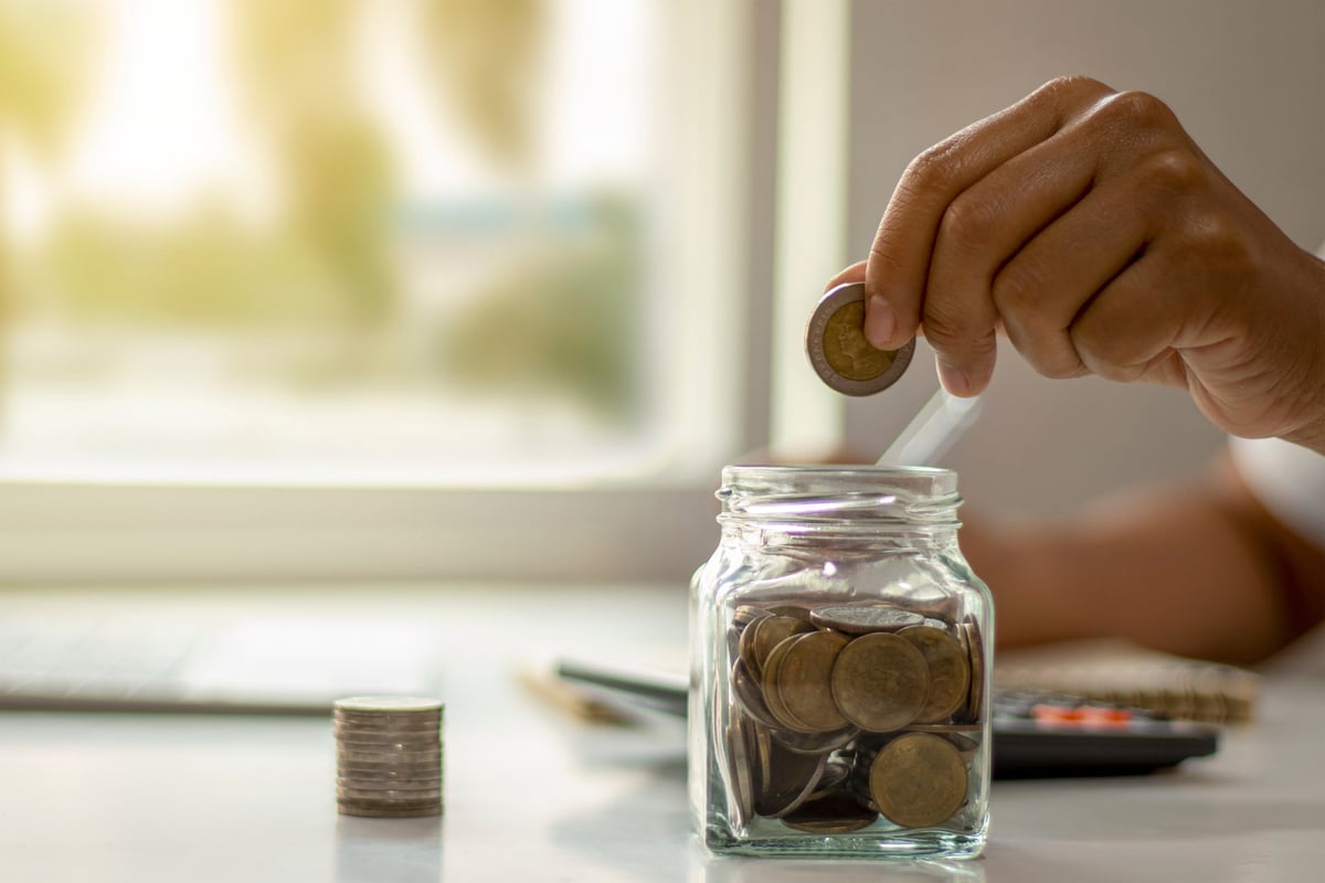 Person Saving Coins in a Jar